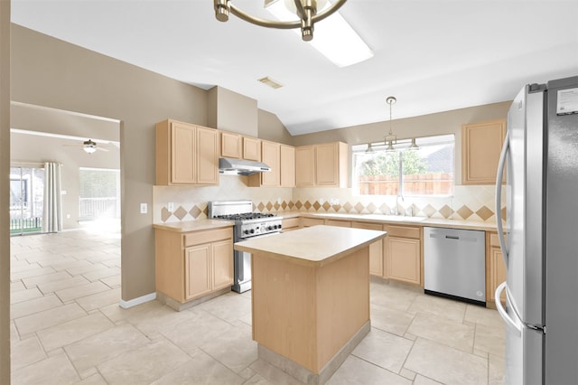 kitchen featuring appliances with stainless steel finishes, tasteful backsplash, ceiling fan with notable chandelier, pendant lighting, and a center island