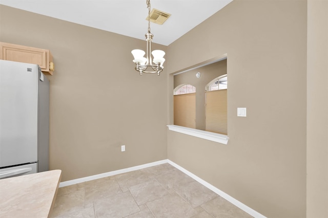 unfurnished dining area with light tile patterned floors and an inviting chandelier