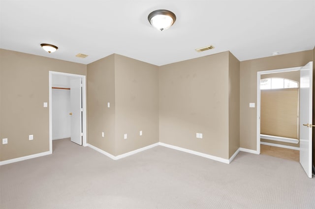 unfurnished bedroom with light carpet and a closet