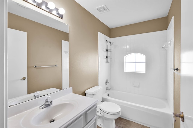 full bathroom with tile patterned floors, vanity, tiled shower / bath combo, and toilet