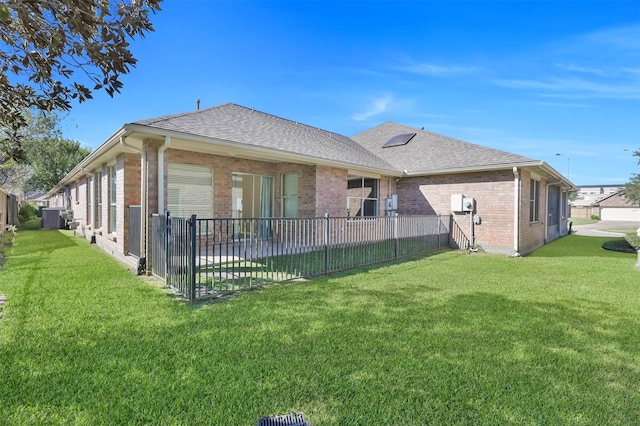 rear view of house featuring a yard and cooling unit