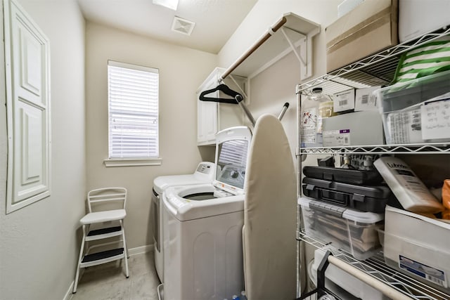 washroom featuring cabinets and washing machine and dryer