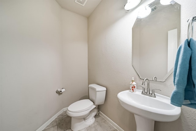 bathroom with tile patterned flooring, toilet, and sink