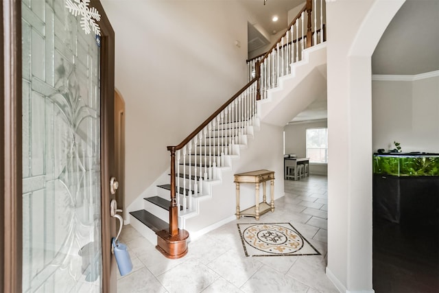 foyer entrance featuring ornamental molding and a high ceiling