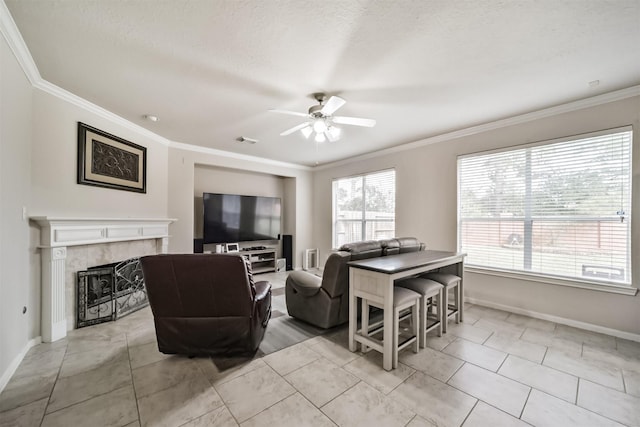 living room featuring ornamental molding, a textured ceiling, ceiling fan, a tile fireplace, and light tile patterned flooring