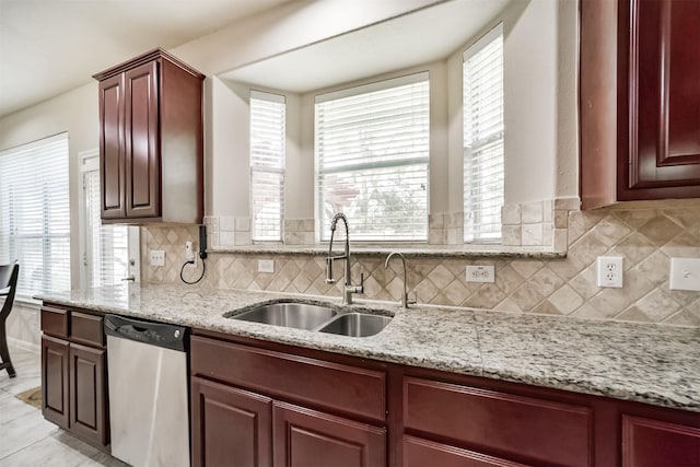 kitchen featuring stainless steel dishwasher, backsplash, sink, and a wealth of natural light