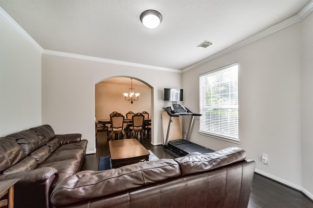 living room featuring crown molding, dark hardwood / wood-style flooring, and an inviting chandelier