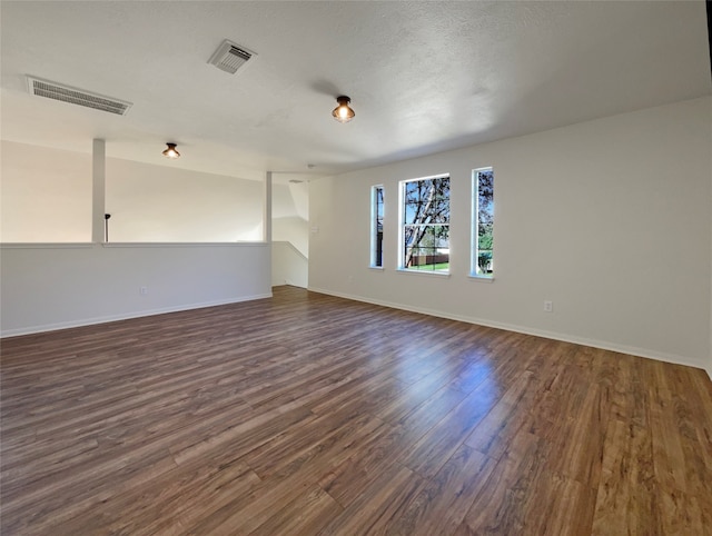 spare room with dark hardwood / wood-style flooring and a textured ceiling