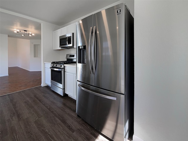 kitchen with white cabinets, stainless steel appliances, and dark hardwood / wood-style floors