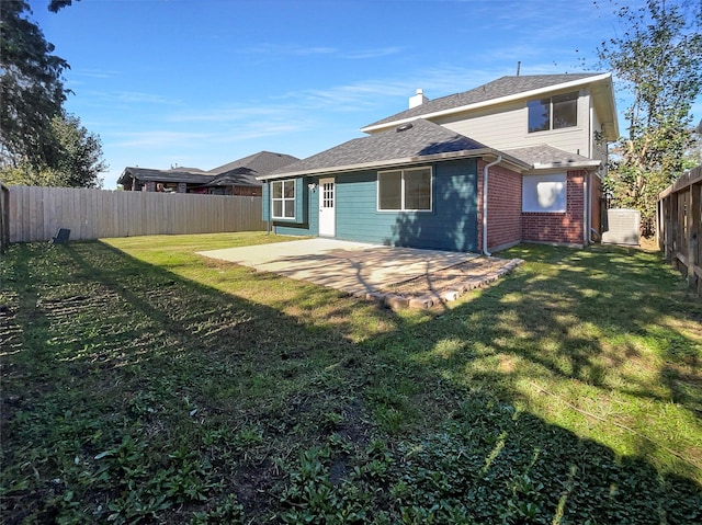 18131 Dusty Terrace Ln, Katy, TX 77449 - rear view of property featuring roof with shingles, a patio area, brick siding, a fenced backyard, and a yard