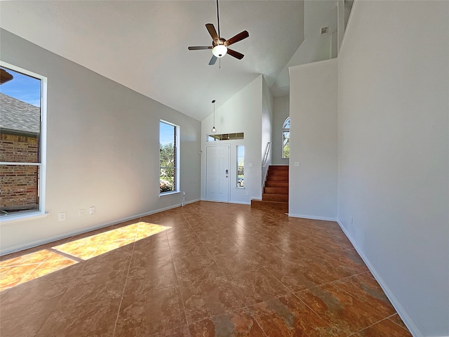 unfurnished living room with ceiling fan and high vaulted ceiling