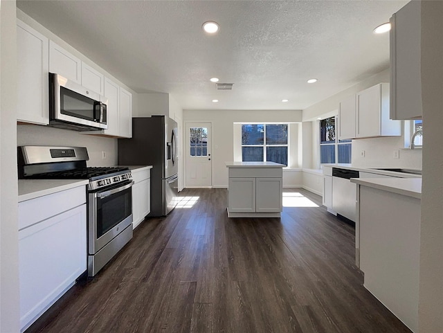 18131 Dusty Terrace Ln, Katy, TX 77449 - kitchen with dark wood finished floors, white cabinets, visible vents, appliances with stainless steel finishes, and a sink
