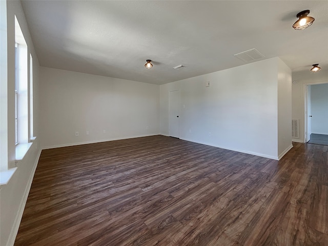 unfurnished room with dark wood-type flooring