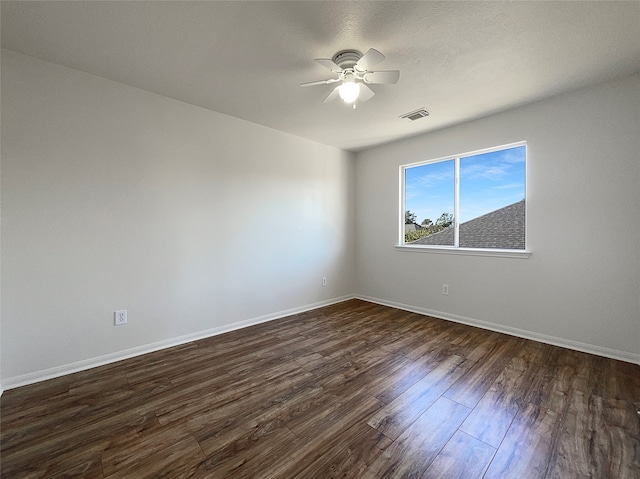 spare room with ceiling fan and dark hardwood / wood-style flooring