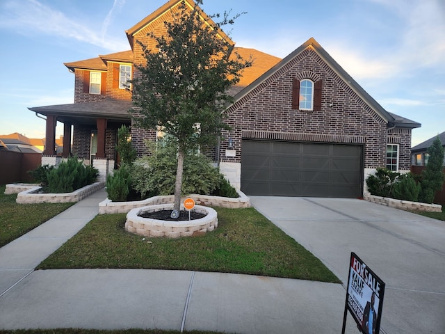 view of front of house featuring a porch, a garage, and a front lawn