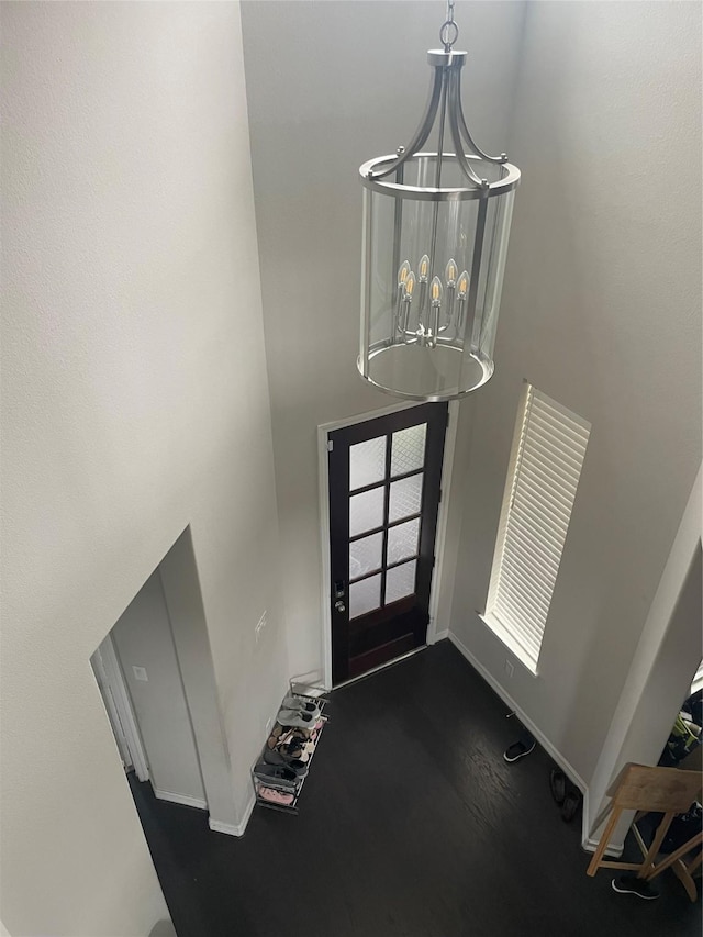 foyer entrance with dark wood-type flooring and a notable chandelier