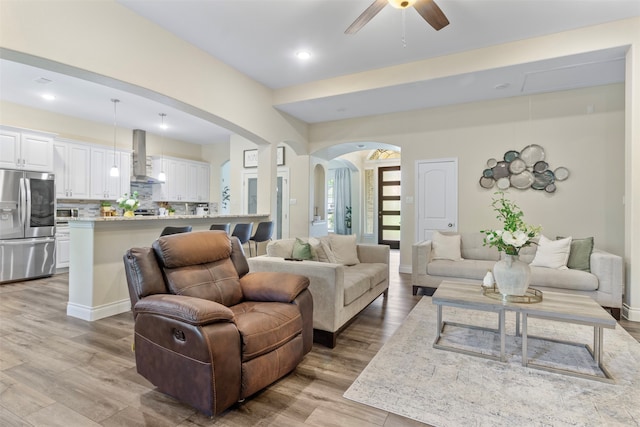 living room with ceiling fan and light hardwood / wood-style flooring