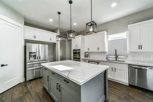 kitchen featuring sink, stainless steel appliances, dark hardwood / wood-style flooring, decorative light fixtures, and white cabinets