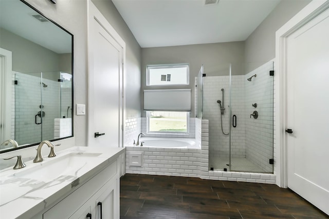 bathroom with hardwood / wood-style floors, vanity, and independent shower and bath