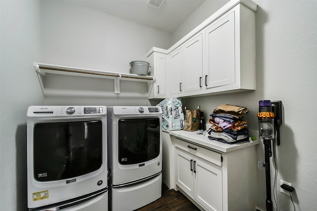 laundry area with cabinets, dark wood-type flooring, and washing machine and clothes dryer