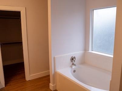 bathroom featuring hardwood / wood-style flooring and a tub to relax in