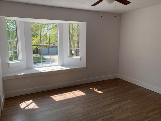 unfurnished room featuring ceiling fan, dark hardwood / wood-style floors, and a textured ceiling