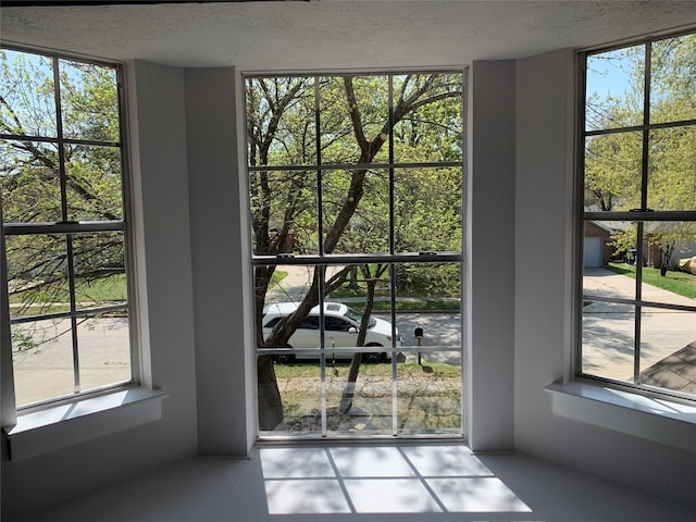 doorway to outside featuring a textured ceiling