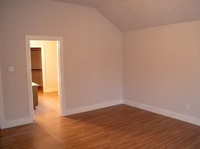 unfurnished room with lofted ceiling and dark hardwood / wood-style floors