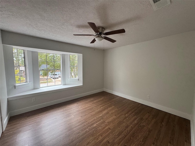 unfurnished room with a textured ceiling, dark wood-type flooring, and ceiling fan