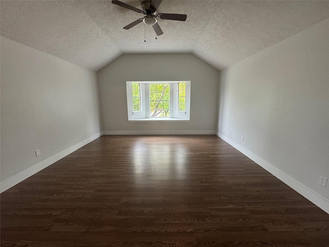 bonus room with lofted ceiling, a textured ceiling, dark hardwood / wood-style flooring, and ceiling fan