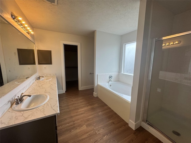 bathroom with vanity, hardwood / wood-style flooring, independent shower and bath, and a textured ceiling