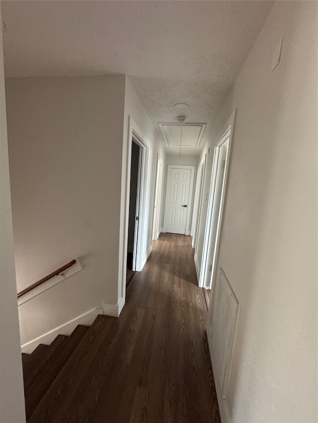 corridor featuring dark wood-type flooring and a textured ceiling