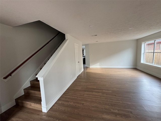 interior space with dark hardwood / wood-style flooring and a textured ceiling