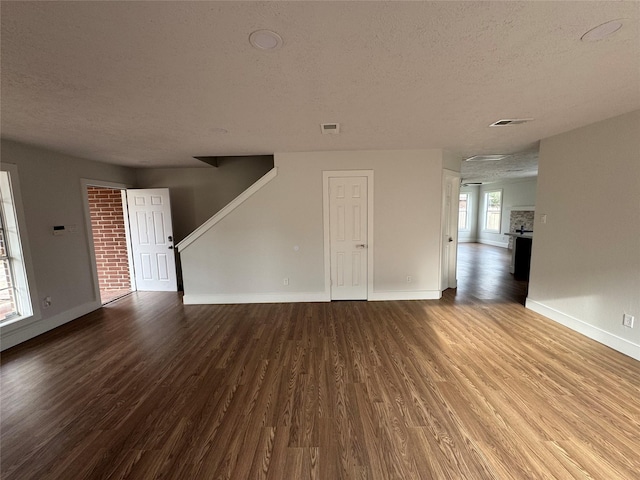 unfurnished living room with wood-type flooring and a textured ceiling