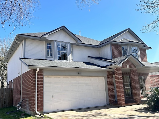 traditional-style house with concrete driveway, a garage, fence, and brick siding