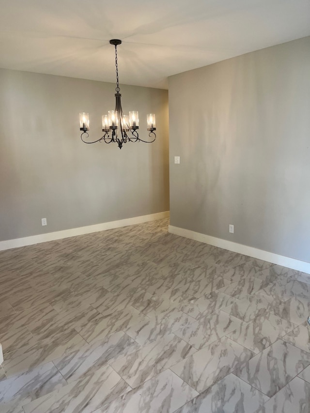 spare room featuring a chandelier