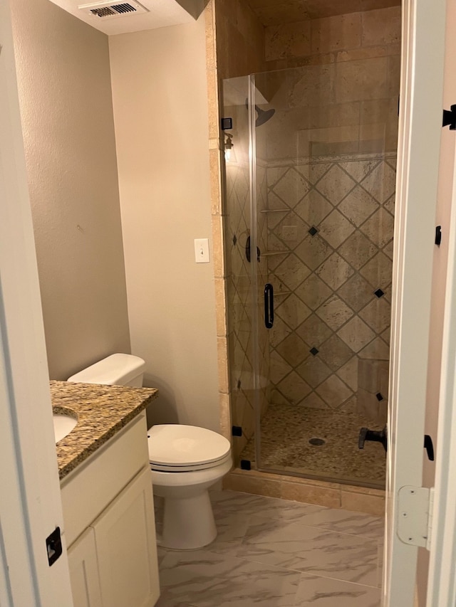 bathroom with vanity, toilet, and a shower with shower door