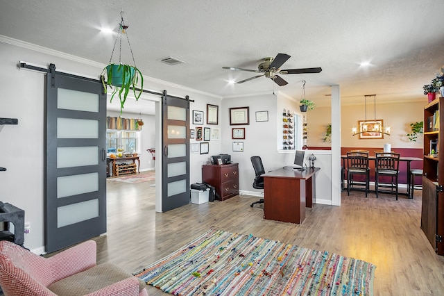 4515 Ponca St, Pasadena, TX 77504 - office with a barn door, crown molding, a ceiling fan, wood finished floors, and a textured ceiling