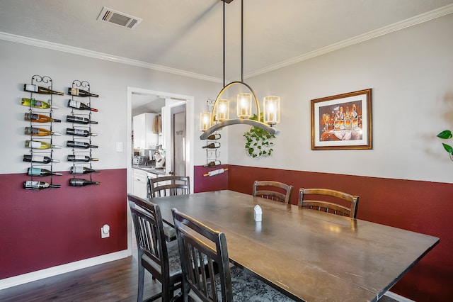 4515 Ponca St, Pasadena, TX 77504 - dining space with dark wood-type flooring, crown molding, baseboards, and a chandelier