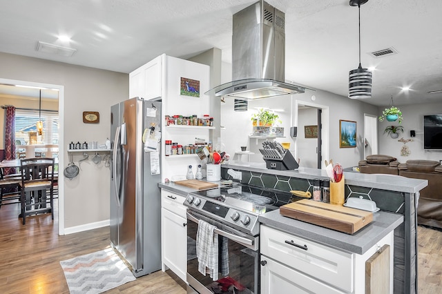 kitchen with hanging light fixtures, light wood-type flooring, appliances with stainless steel finishes, island range hood, and white cabinetry