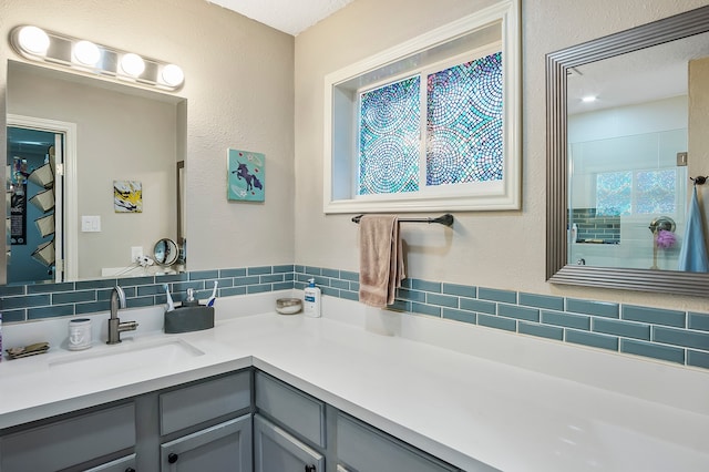 bathroom with vanity, a textured ceiling, and tasteful backsplash