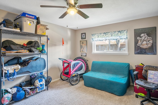 interior space featuring carpet flooring, a textured ceiling, and ceiling fan