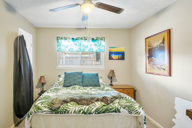 bedroom featuring carpet, ceiling fan, and a textured ceiling