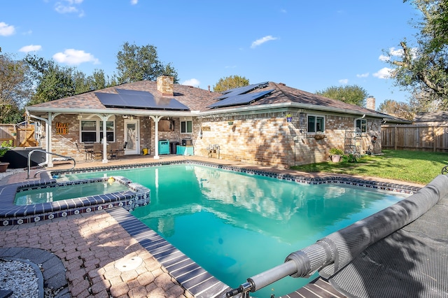 view of pool featuring an in ground hot tub, a patio, and a lawn