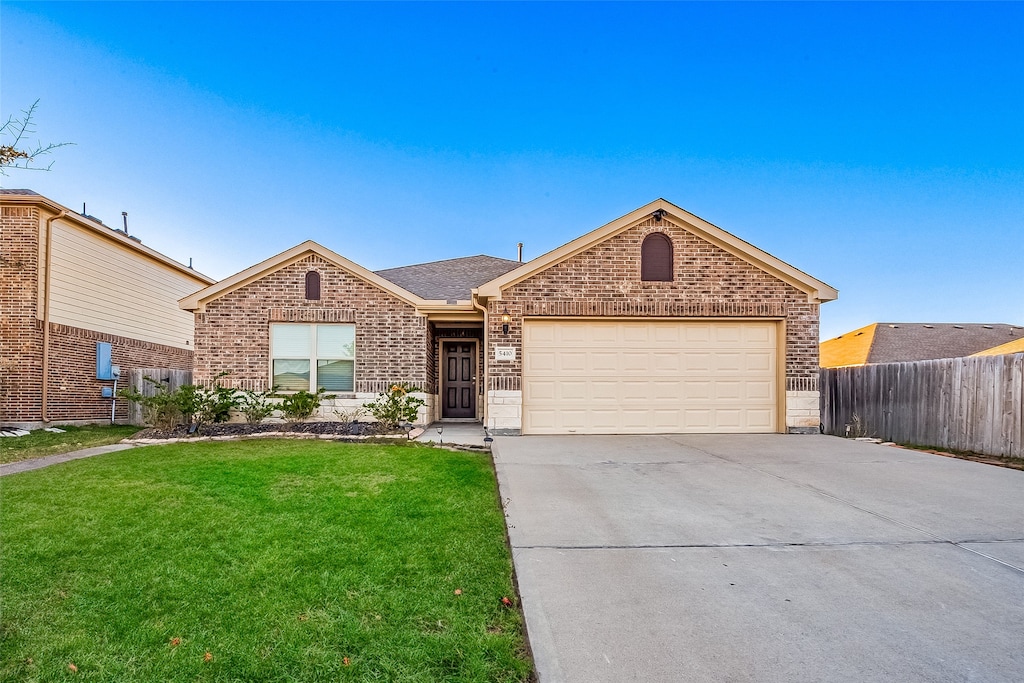 single story home featuring a garage and a front lawn