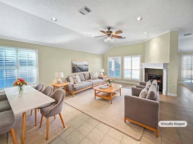 living room with a large fireplace, ceiling fan, light tile patterned flooring, and lofted ceiling