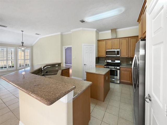 kitchen with appliances with stainless steel finishes, sink, light tile patterned floors, a kitchen island, and hanging light fixtures