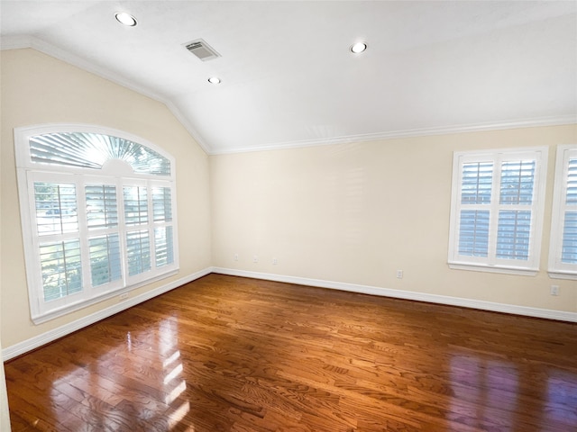 spare room featuring a healthy amount of sunlight, lofted ceiling, and hardwood / wood-style flooring