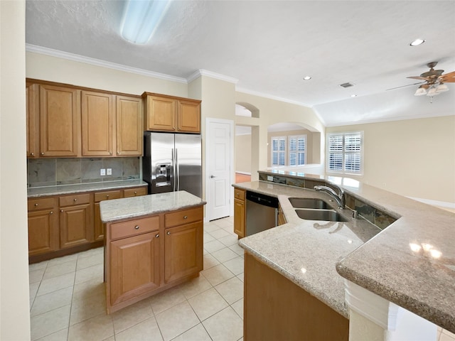 kitchen featuring light stone countertops, sink, a center island, and stainless steel appliances