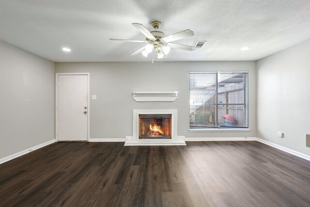 unfurnished living room featuring a textured ceiling, ceiling fan, and dark wood-type flooring